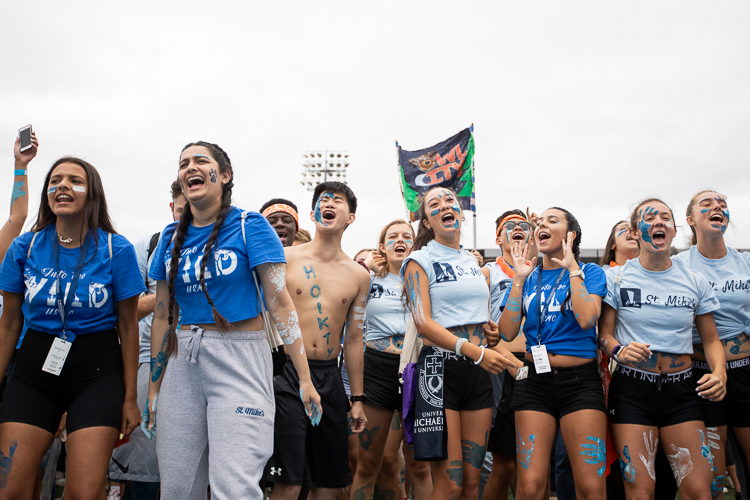 A group of students cheer at parade on the varsity field.