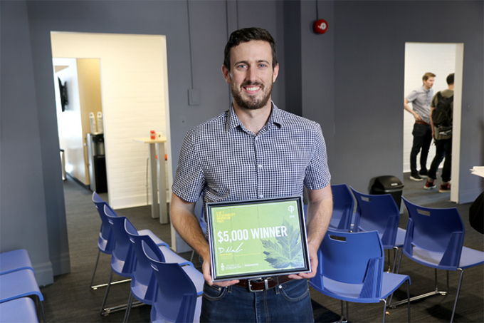 Daniel McKee holding an award.