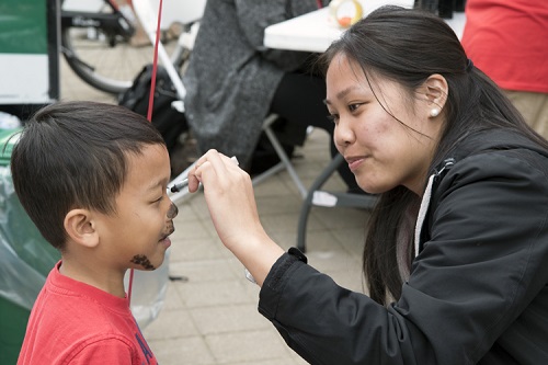 A woman painting a young child's face
