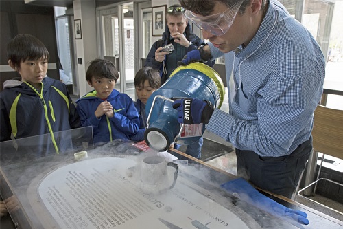 A scientist pouring liquid nitrogen in a mug