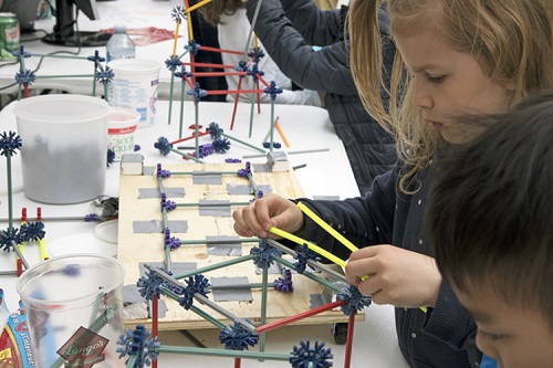 A young girl building a Kinex structure