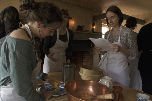 Students reading recipes while cooking