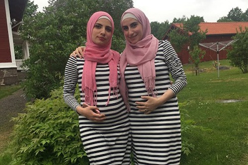 Noura Al-Jizawi with her sister, Alaa. They are wearing matching dresses, pink hijabs and are cradling their stomachs