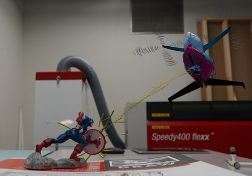 A Captain America figure battles an augmented reality drawing of an airplane. 