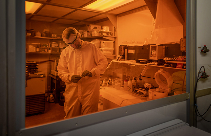 Axel Guenther, scientific director in the Centre for Microfluidic Systems, inspects microfluidic devices in a cleanroom.