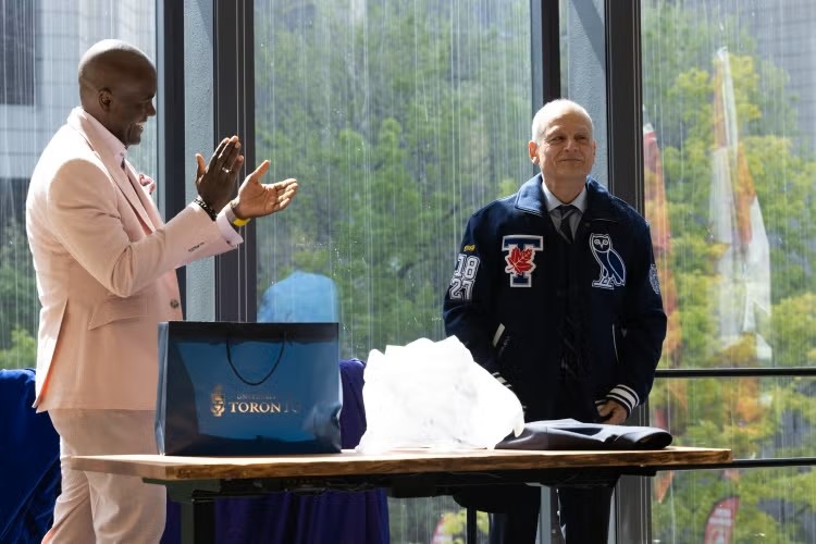 Chancellor Wes Hall applauds as President Meric Gertler.
