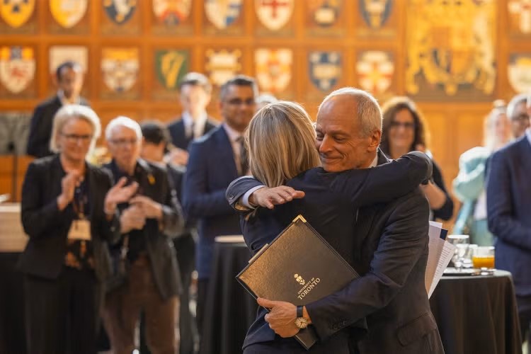 U of T President Meric Gertler and Melanie Woodin embrace.