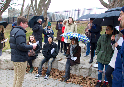 A student tells a story at the Philosopher's Walk amphitheatre while other students look on.