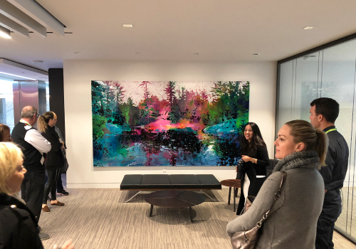 Angelica Demetriou standing in front of a beautiful colourful painting.