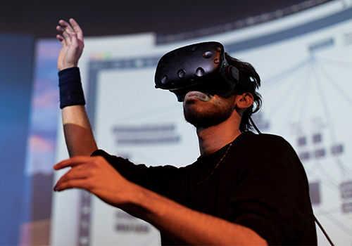 U of T drama student rehearsing on a stage with a virtual reality mask on.