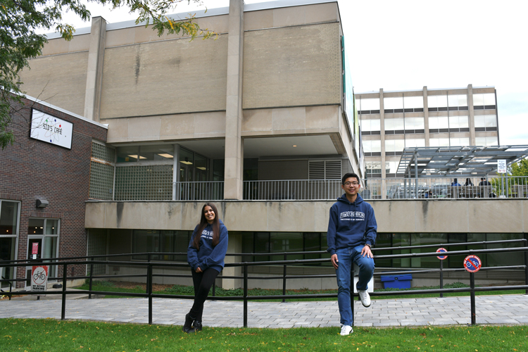 Veronica Bergstrom and Andew Yin stand in front of Sidney Smith Hall.