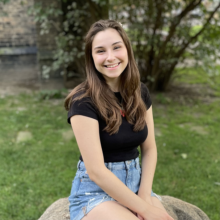 Ella sitting on a rock outdoors