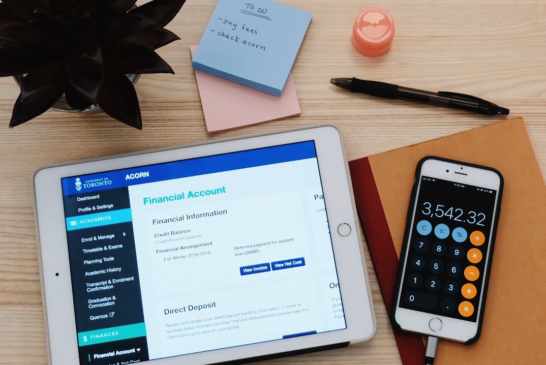 Flat lay photo showing a student's financial account on ACORN and a calculator