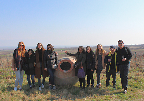 Group of students posing with a traditional winemaking vessel in Georgia