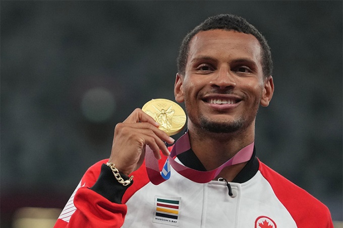 Andre De Grasse holing his medal