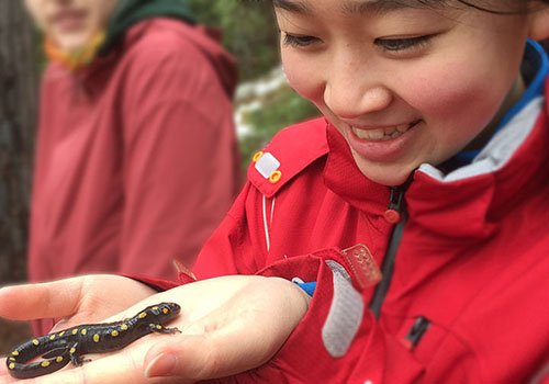Student holding a lizard on her palm
