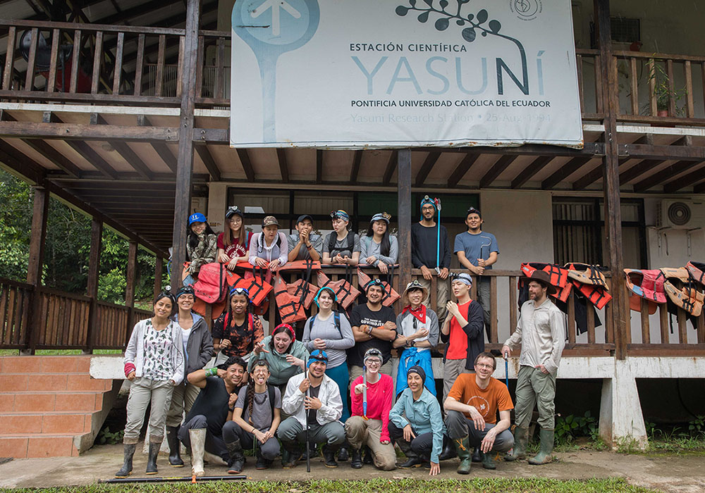 A group of undergraduate students and instructors pose in front of a two-storey wooden building at the Yasuni Research Station