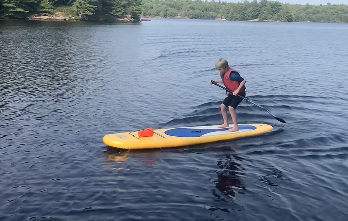 A child standing on a paddleboard