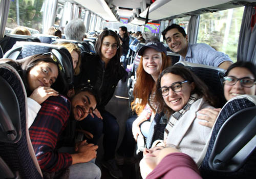 A group of students posing for a picture on a bus.