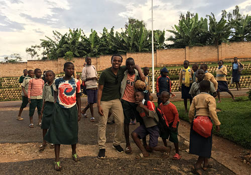 A group of young people posing for a picture outdoors in Rwanda.