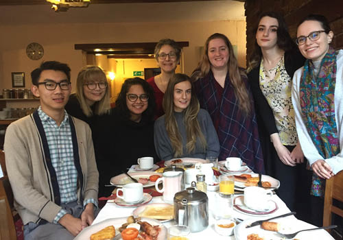 A group of students pose for a picture at breakfast.