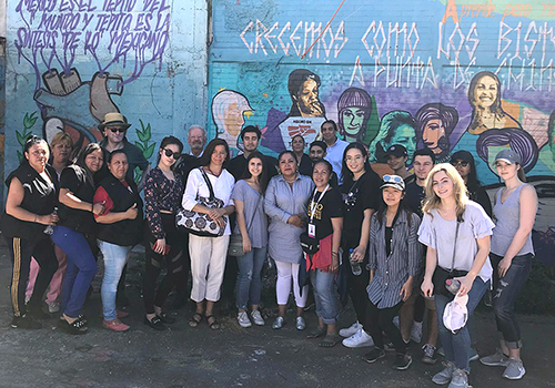 Group of students in front of a wall with graffiti in Mexico
