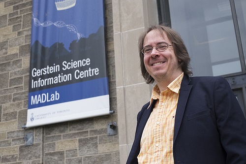 Miller in front of a sign for U of T’s Gerstein Science and Information Centre