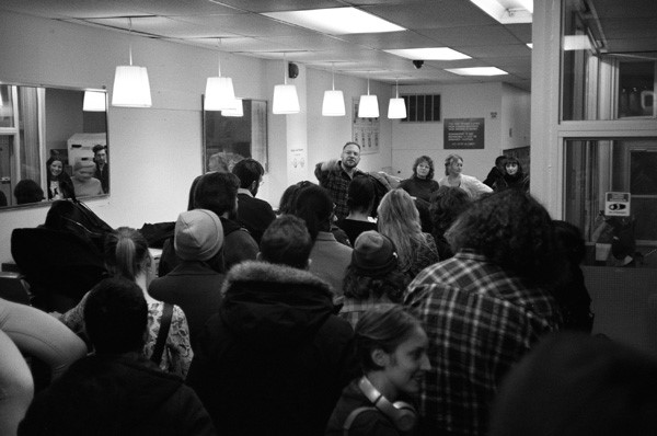 Zak Jones standing and pointing in-front of a large indoor crowd.