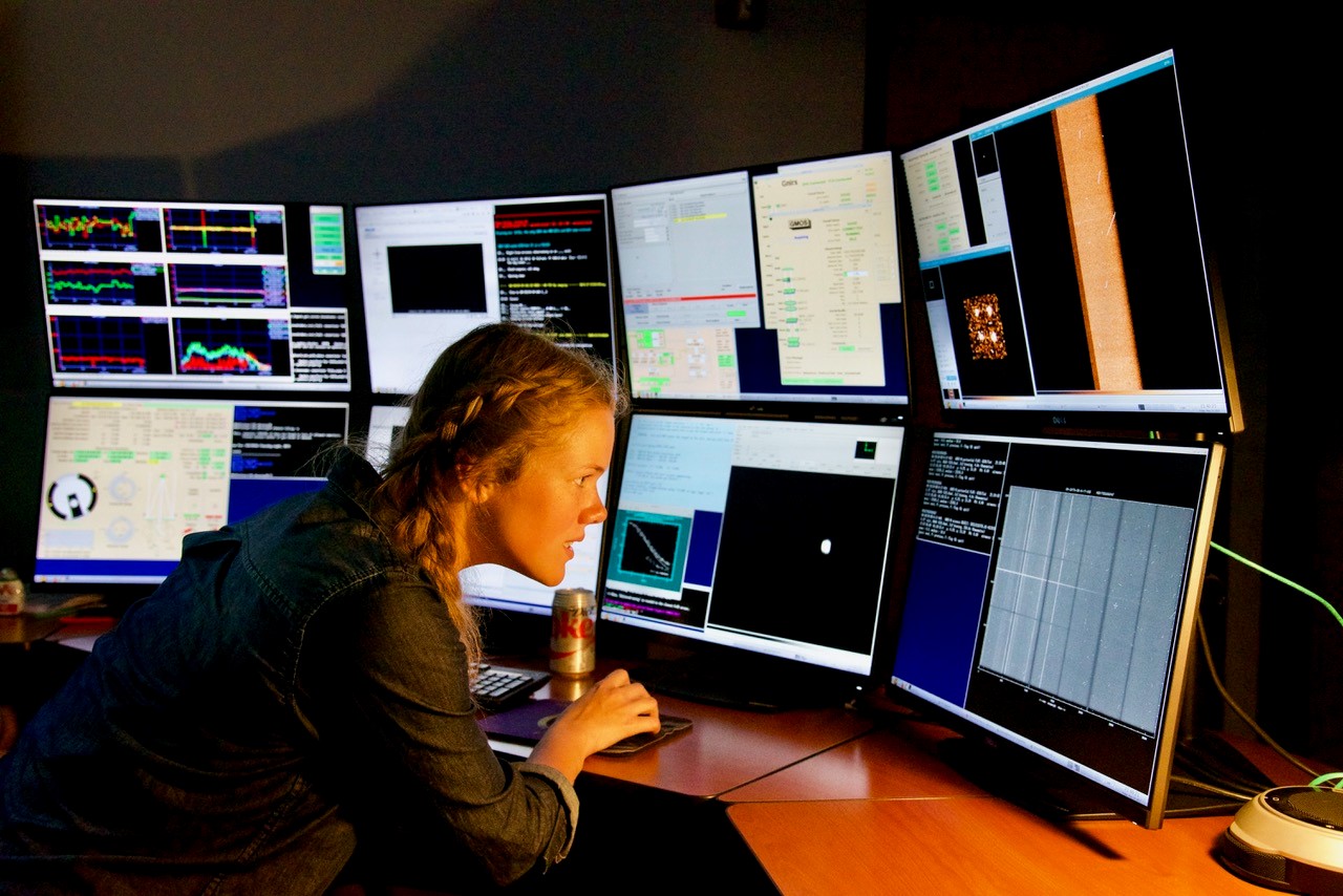 Katie Harris observing multiple screens on a computer closely.