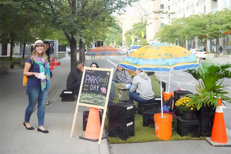 U of T geography and planning’s Kelly Gregg and Sneha Mandhan standing next to the team’s PARKing day installation on Bloor Street West