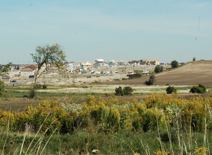 An open field with building in the distance.