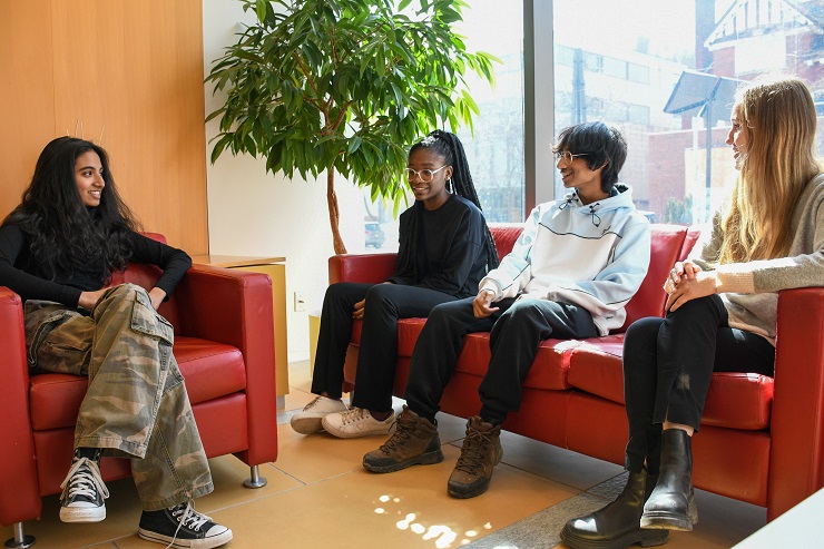 Four students sitting on couches having a conversation in their learning communities