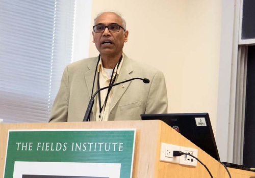 Kumar Murty speaking at a podium.