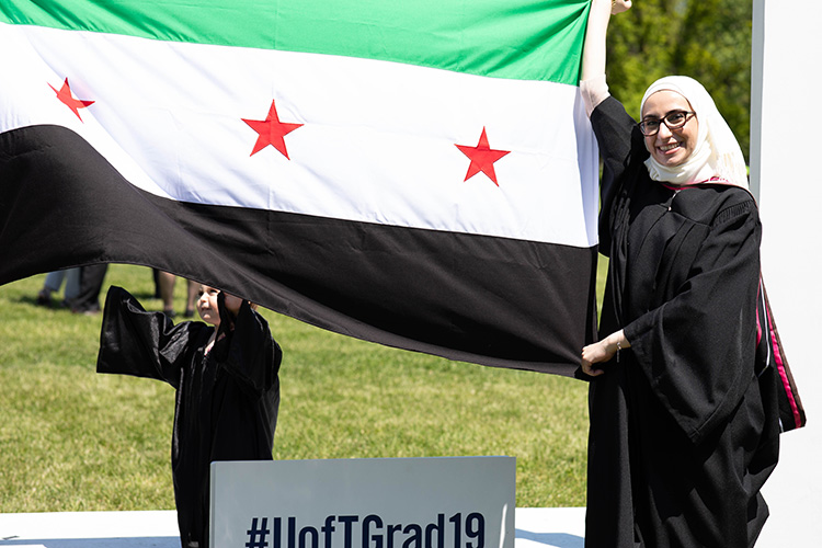 Noura Al-Jizawi and her daughter display the Syrian independence flag after convocation on June 7, 2019.