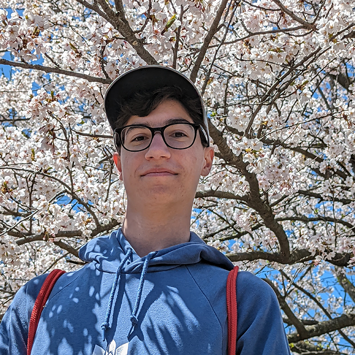 Photo of Greg in front of a cherry blossom tree