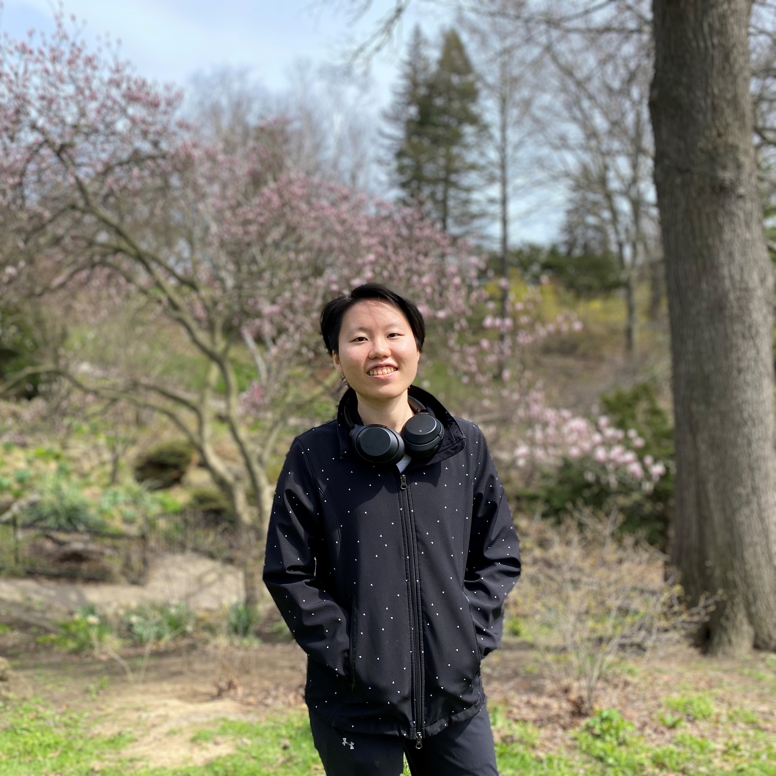 Shih Hua Lai, New College Life Science FLC peer mentor, stands outdoors in front of cherry blossom trees