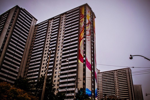 Red and yellow mural painted on the side of a social housing building.