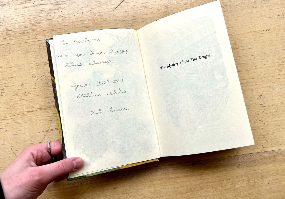 Open pages of the book, "The Mystery of the Fire Dragon" and a handwritten note that says, 'Hope you have happy times always, yours till the kitchen sinks'.