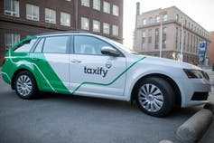 A white and green Taxify car.