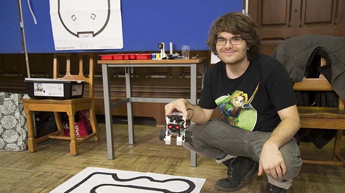 Student Andrew Scicluna holding a small robot