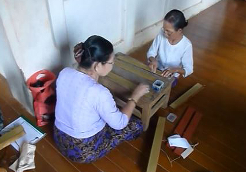 Two volunteers sit at a small table.