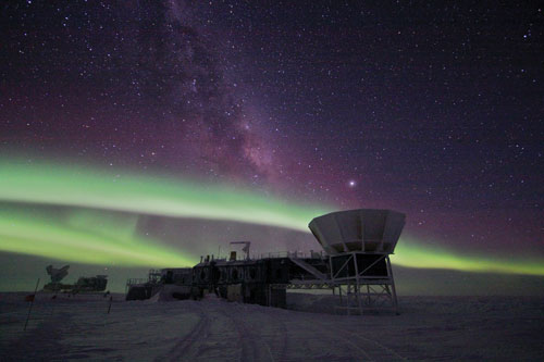 An image of a giant telescope at the South Pole with Northern lights.