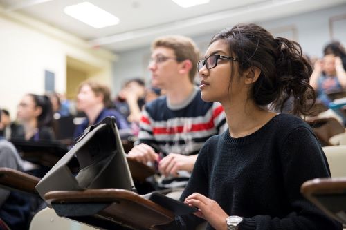 Class in session with one student in the foreground looking intently at the professor