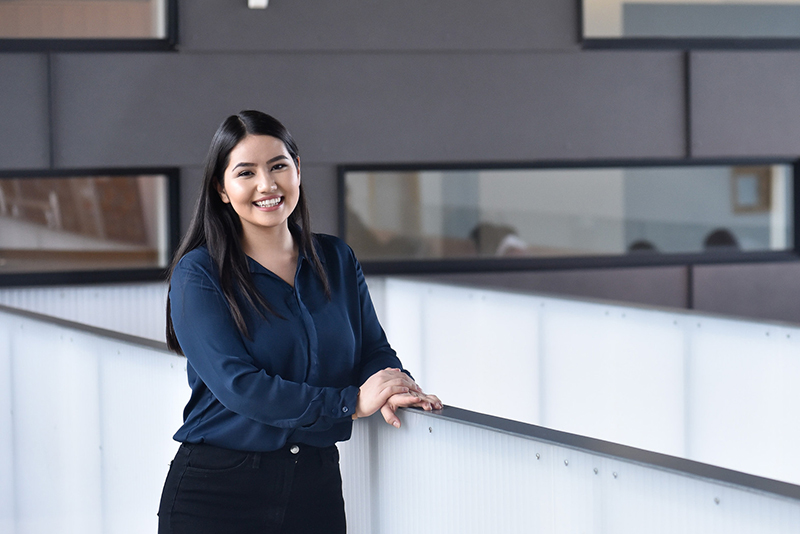 Student in business attire standing in an office space