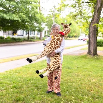 Anne Innis Dagg holding a stuffed giraffe.