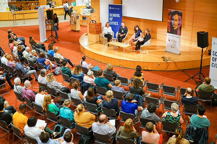 Audience members watching a panel discussion 