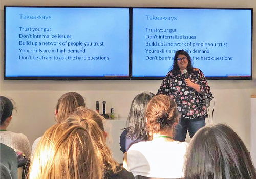 Aashni Shah presenting in front of a group of people at a conference.