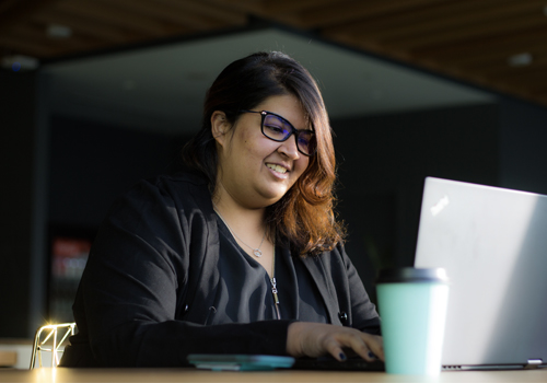 Aashni Shah typing on a laptop.