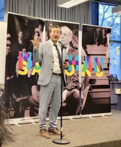  Paolo Granata standing in front of a banner of Marshall McLuhan