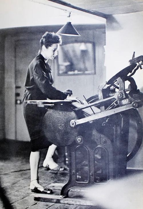 Black and white image of Anaïs Nin operating a letterpress